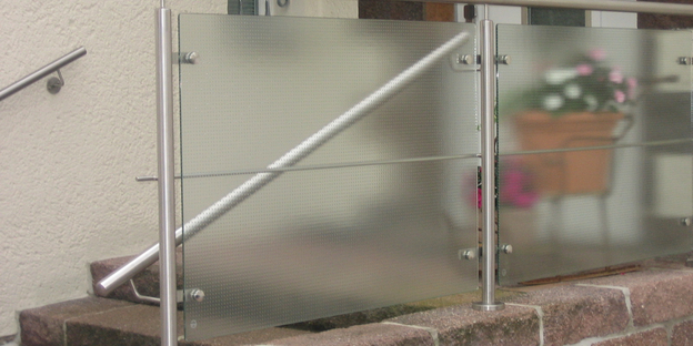 punktgehaltenes Glasgeländer am Eingang eines Wohnhauses
